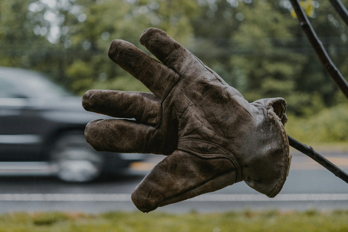 Gants en cuir brun posés sur l'herbe verte