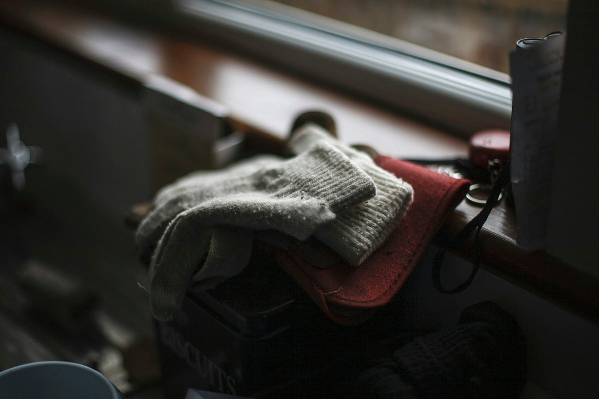 Paire de gants tricotés posée sur un rebord de fenêtre