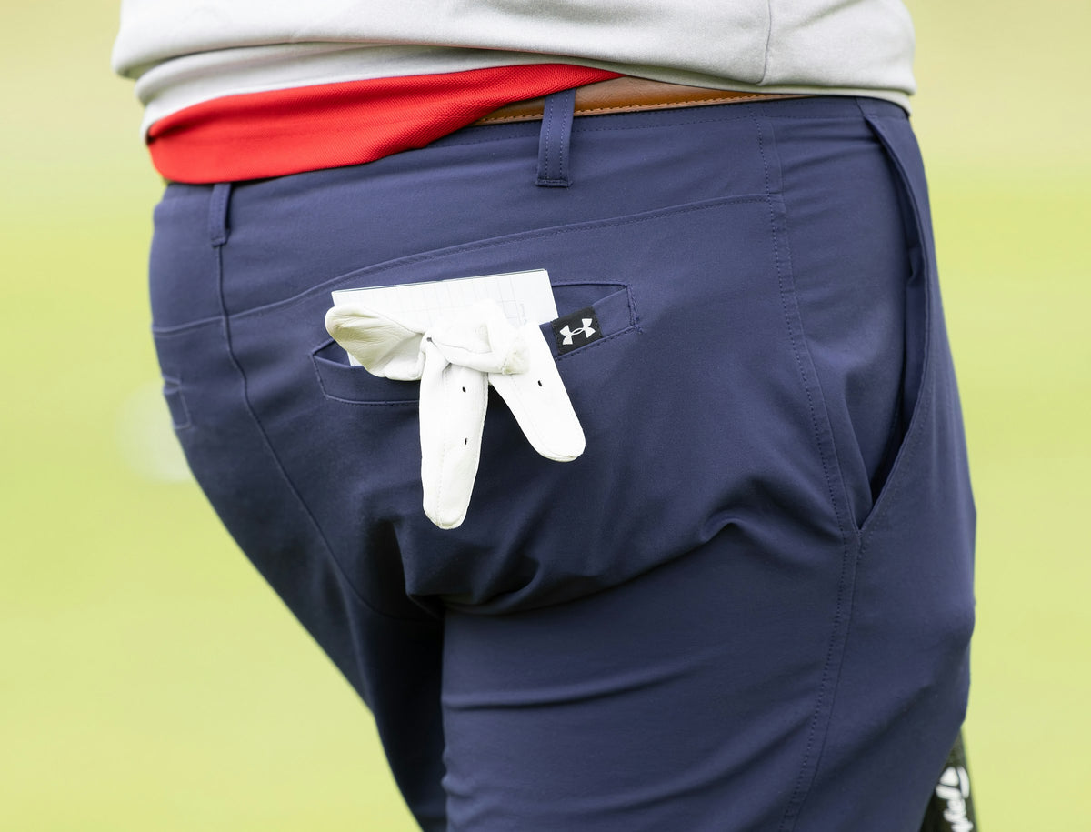 Gant de golf blanc glissé dans la poche arrière d'un pantalon