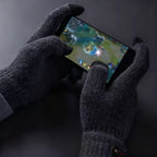 Mains gantées de gris foncé touchant l'écran d'un smartphone