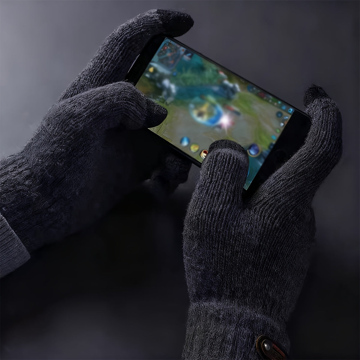 Mains gantées de gris foncé touchant l'écran d'un smartphone
