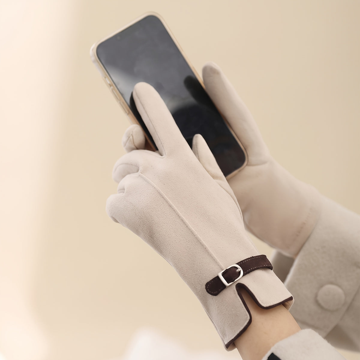 Gants femme crème portés en tenant un téléphone