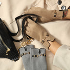 Gants femme camel et gris à détail mors doré, posés avec un sac noir