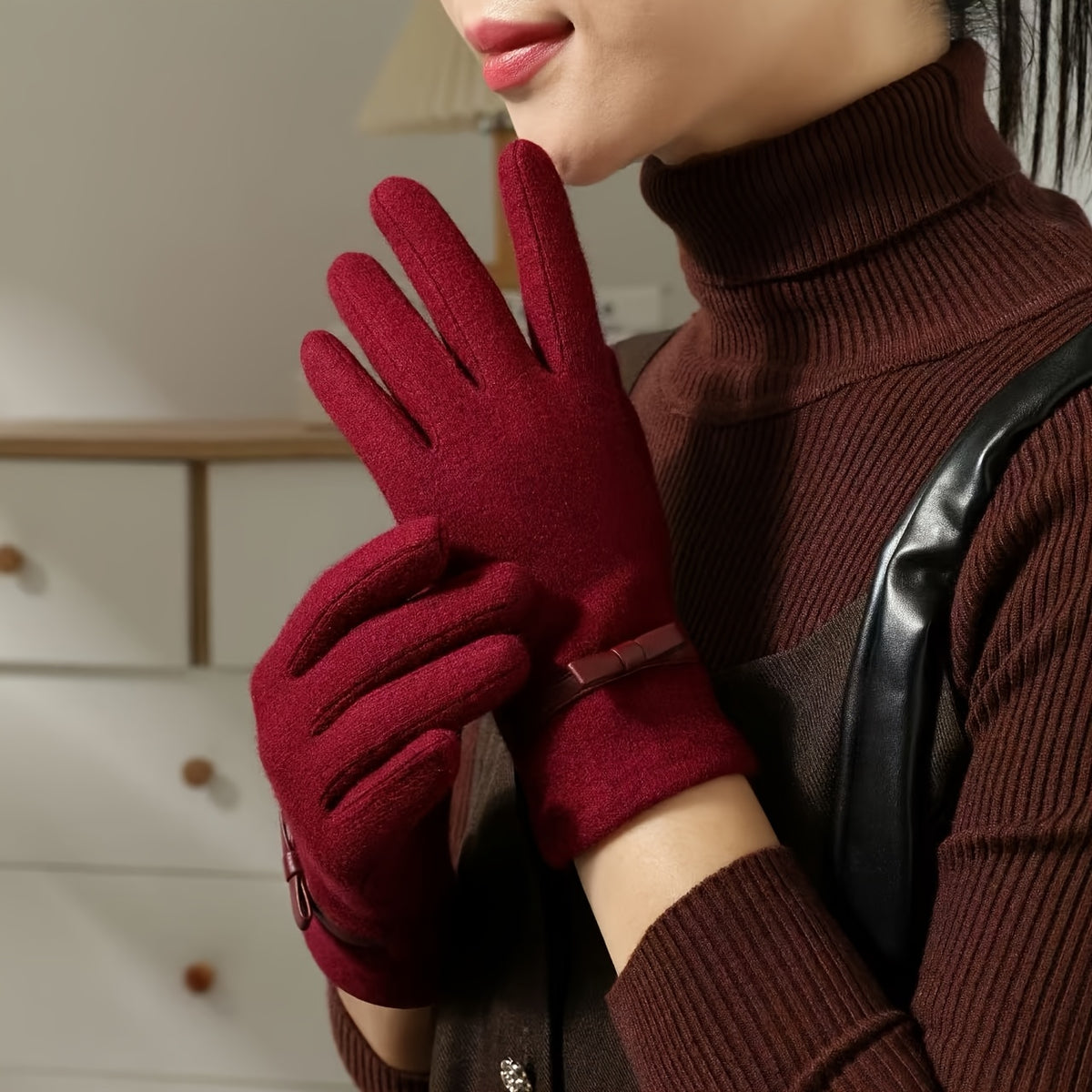 Gants en laine femme bordeaux portés près du visage