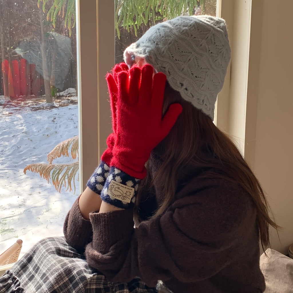 Gants longs femme rouges portés devant une fenêtre enneigée
