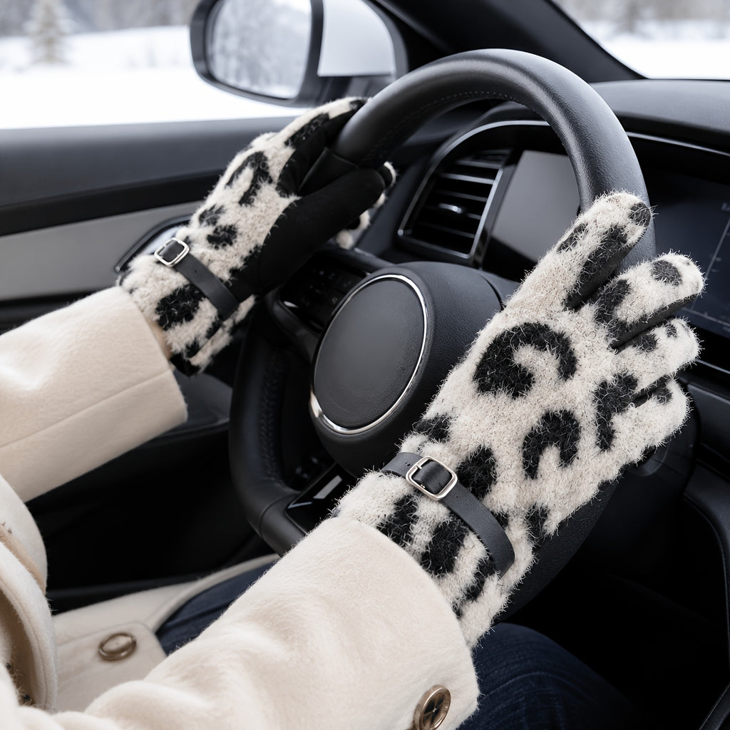 Gants femme léopard beige et noir portés sur un volant, en hiver