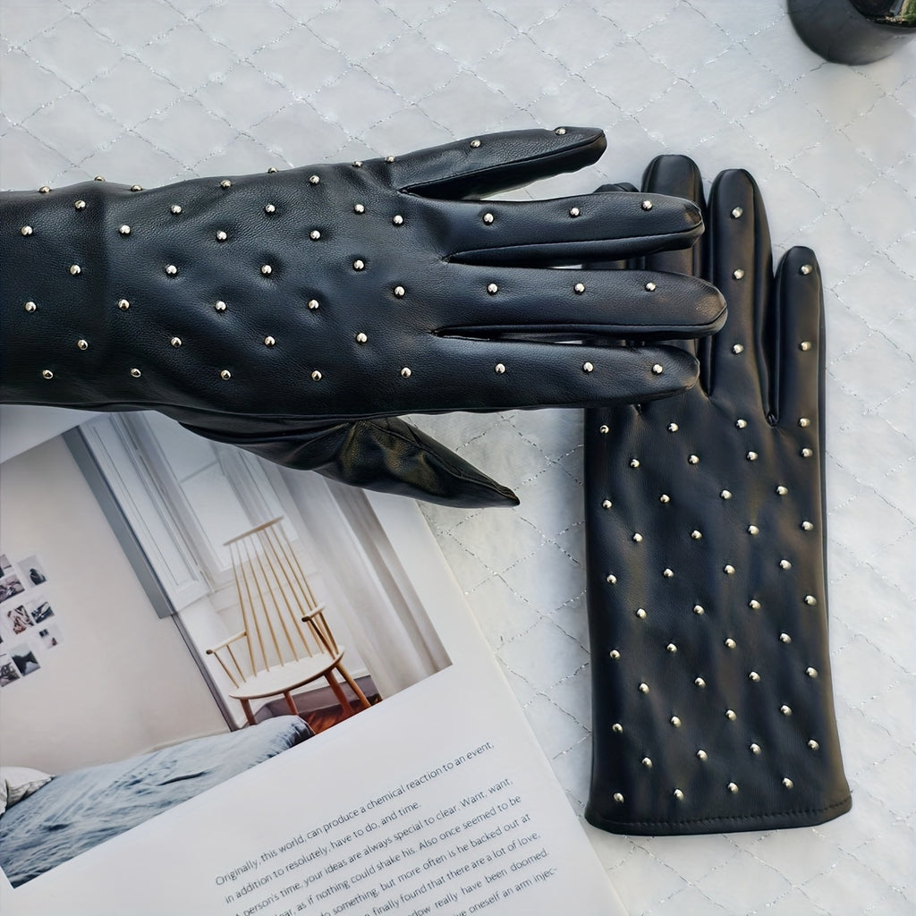 Gants femme cuir PU noir à clous métalliques, posés sur un livre