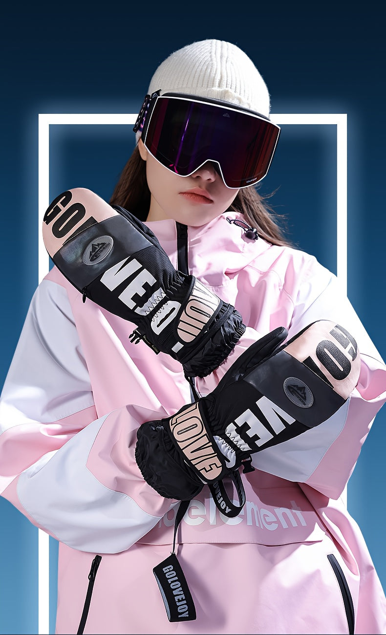 Femme en veste rose portant des gants de ski moufle noir et rose