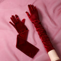 Gants longs femme en velours bordeaux, posés à plat