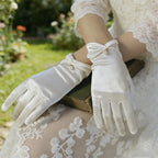 Gants de cérémonie femme en satin blanc, gros plan sur le poignet froncé et la perle
