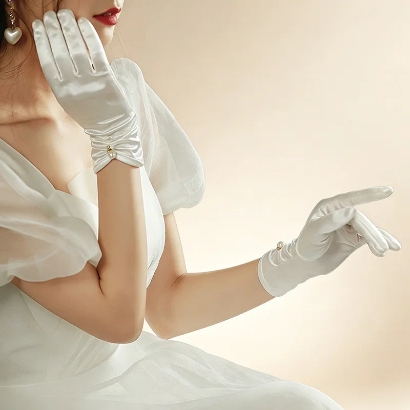 Gants en satin blanc portés avec une robe de soirée, vue de profil