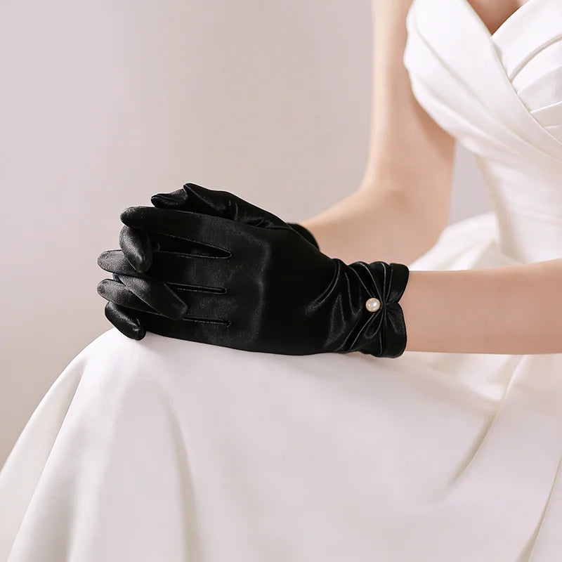 Gant femme en satin noir porté, vue rapprochée du fronçage du poignet