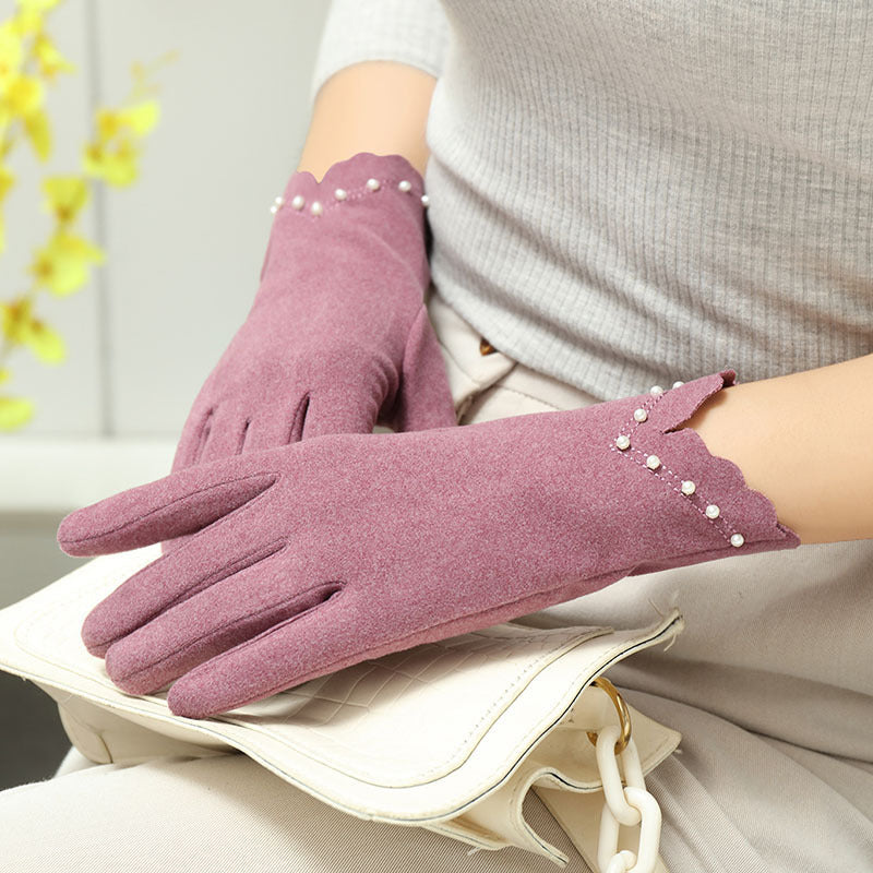 Gants tactiles femme mauves portés, main posée sur un sac matelassé
