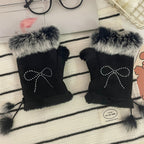 Mitaines femme noires posées à plat, nœud en strass et pompons